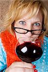 Crazy woman with wild eyes drinking wine