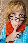 Crazy woman with glasses putting her finger to her lips