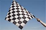 Auto racing checkered flag on a background of the  blue sky.