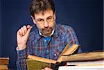 Mature man in glasses reading his book