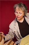 Mature woman with heaps of books and note pad