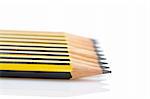 Assortment of pencils reflected on white background. Shallow depth of field