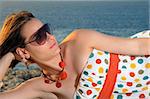 Portrait of young woman relaxing outdoors by the ocean