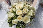 white fine rose in wedding bouquet in hand