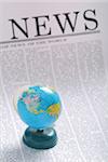 global news concept. small globe on a newspaper page.