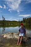 Young African American child playing in a lake at Yellowstone National Park in Wyoming, USA.