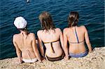 Teen girls sit on the coast