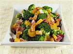 Broccoli salad with bacon, raisins, cashews, mandarin oranges, cheddar cheese, red onion, and a sweet mayonnaise dressing.