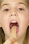 Young female child opening her mouth so the Doctor can examine her throat.