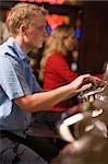 Man playing slot machines in casino