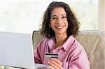 Woman making online purchase at home looking to camera