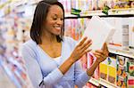 Woman checking food labelling on packet in supermarket