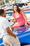 Woman talking to car salesman at lot