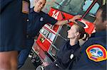 Firefighters chatting by a fire engine