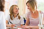 A schoolgirl sitting with her teacher in class