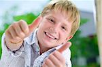 Portrait of young boy giving his thumbs up