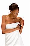 Beautiful young Afro American female with Slicked Back Hair wrapped in white bath towel preparing for sauna