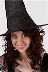 Portrait of Hispanic teenager girl in black Halloween hat and fishnet dress