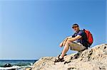 Middle aged hiker sitting on a rock