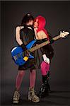 Two rock girls with bass guitar kissing