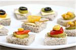 Fruit and vegetable canapés on a white ceramic plate