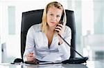 Businesswoman in office with personal organizer open on telephon