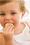 Baby indoors eating apple