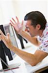 Man in computer room frustrated at monitor