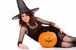 Portrait of Latina teenager girl in black Halloween hat and fishnet dress with carved pumpkin (Jack O' Lantern)