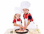 Two kids dressed as chefs preparing a pizza - isolated