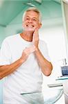 Man in bathroom applying aftershave and smiling