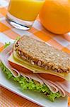 Fresh wholemeal cheese and ham sandwich with orange juice