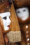 White mask  with a brown costume at the Venice Carnival