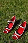 a pair of red high heels on a grass lawn