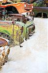 abandoned cars in the snow at a junkyard