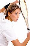 side view of young woman ready to play tennis with white background