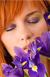 Close-up of young woman with purple makeup closed eyes and flowers