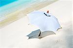 View of white parasol on sunny tropical beach