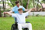 Disabled senior man does stretching exercise with the help of his physical therapist.
