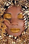 African American Woman With Eyes Closed Wrapped in Metallic Leaves