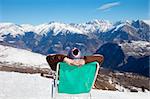 rear view of woman resting on chair in mountain