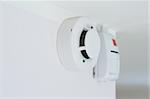 smoke detector and alarm mounted on a wall, shallow DOF