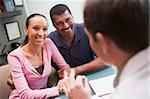 Couple in discussion with doctor in IVF clinic sitting at desk