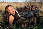 young woman and her blackhorse laid down in a field