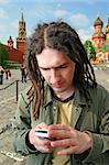 Young man with dreadlock hair and mobile phone.