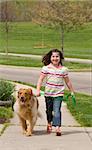 Girl Walking Down the Sidewalk With Dog