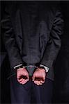 Close-up. Arrested businessman handcuffed hands at the back