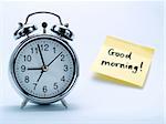 An alarm clock and a yellow note with this text 'Good morning!'