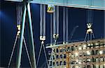 Detail of cranes and hooks in a shipyard by night