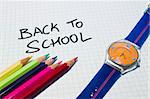 A checked paper with the words "back to school" in it. There are some color pencils and a kid clock in the borders.